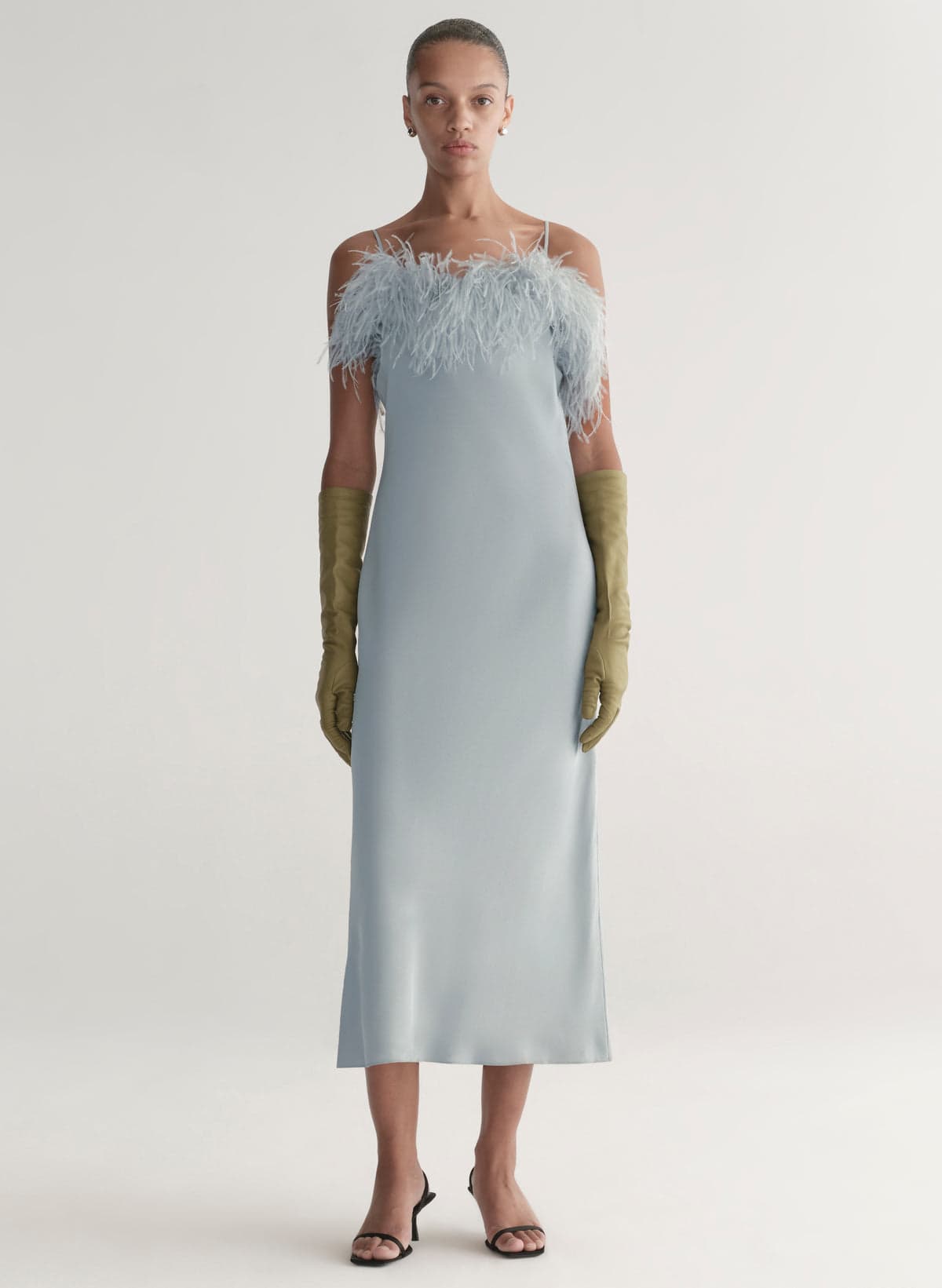 Model wearing a feather-trim slip dress